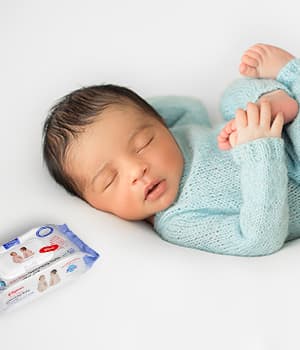 Mother and baby lying on cream knit blanket
